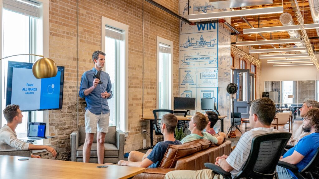 Teammates sitting in the office listening to a presentation