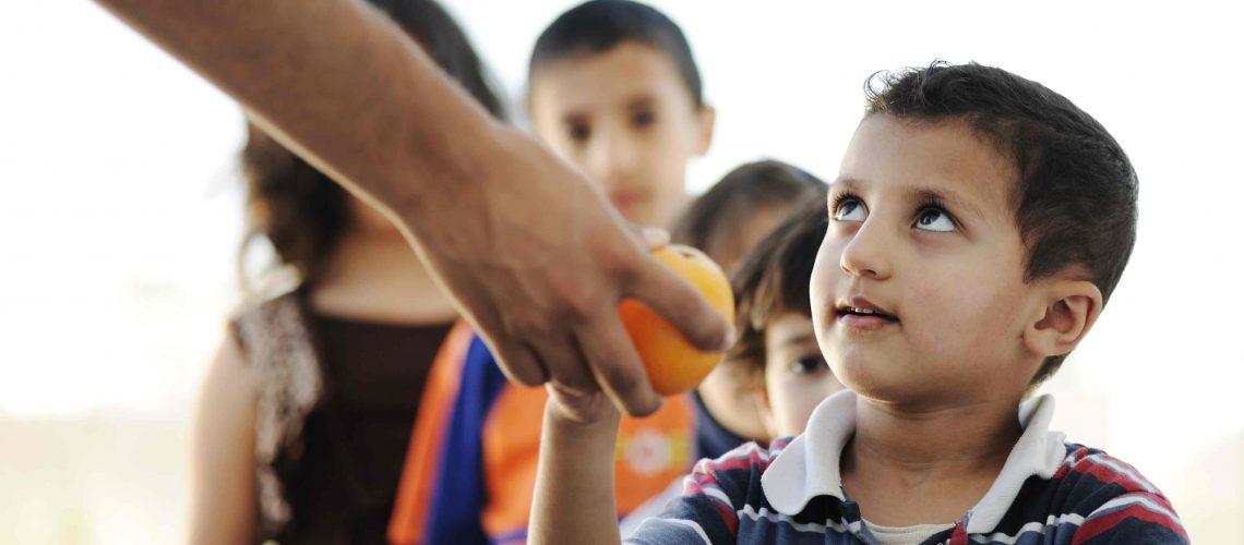 Hungry children in refugee camp, distribution of humanitarian food